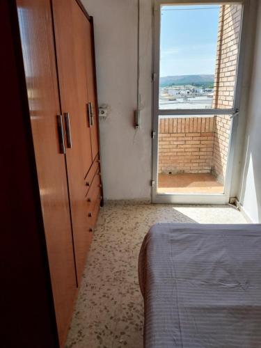 a bedroom with a bed and a large window at Habitación Mercadona B in Cantillana