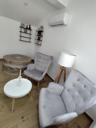a living room with a couch and a chair and a table at Moinho do Zorrão in Manteigas
