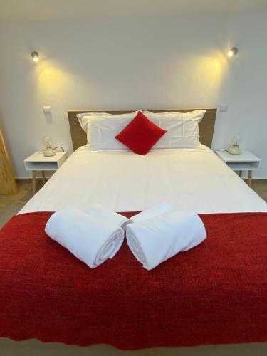 a large white bed with two pillows on it at Moinho do Zorrão in Manteigas
