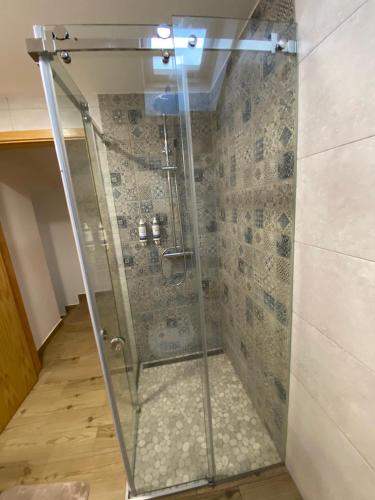 a shower with a glass door in a bathroom at Moinho do Zorrão in Manteigas