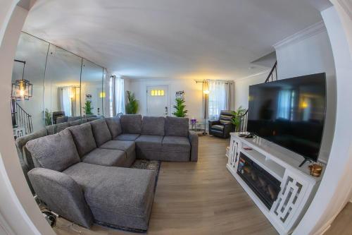 a living room with a couch and a flat screen tv at ComfiNook Cozy Suburb Stay Philly Airport Parking