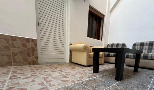 a living room with a table and a chair at Hotel Barjami in Sarandë