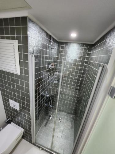 a bathroom with a glass shower with a toilet at Antalya Sirius Town Residence in Antalya