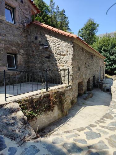 a stone building with a gate on the side of it at Moinho do Zorrão in Manteigas