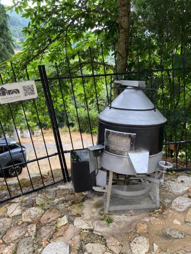 a grill sitting in front of a fence at Moinho do Zorrão in Manteigas