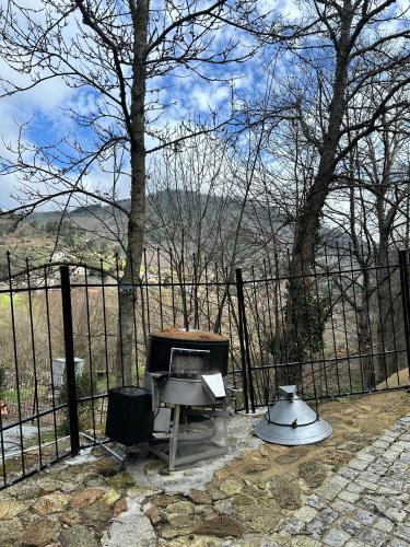 a grill and a blender next to a fence at Moinho do Zorrão in Manteigas