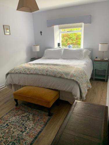 a bedroom with a large bed and a window at Chatterbox Cottage 