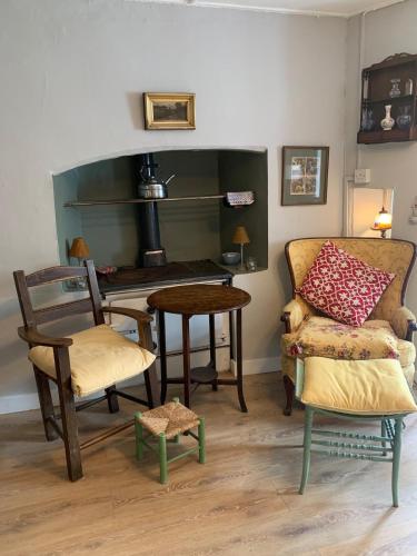 a living room with a couch and a table and chairs at Chatterbox Cottage 