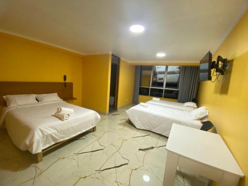 a hotel room with two beds and a table at Los ROYALS Hotel Huaraz in San Antonio