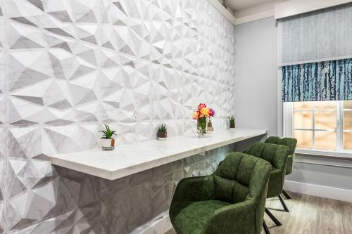a lobby with a marble counter and green chairs at Lumea by the Sea in Long Beach
