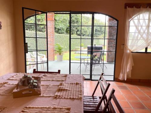 a dining room with a table and a large window at Colonial-style house in Villarrica