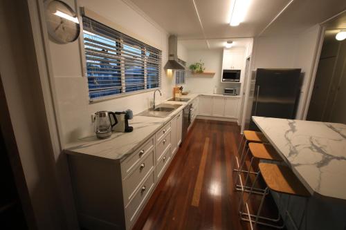 a kitchen with white cabinets and a counter top at Bundaberg Dream 