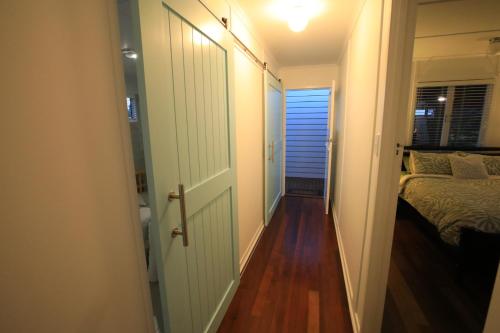 a hallway leading to a bedroom with a bed and a door at Bundaberg Dream 