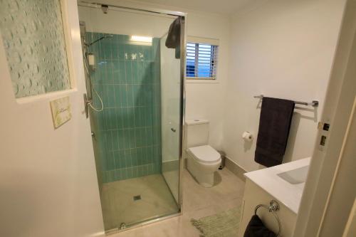 a bathroom with a shower with a toilet and a sink at Bundaberg Dream 