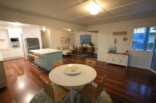 a kitchen and living room with a table and chairs at Bundaberg Dream 