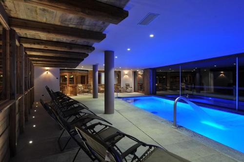 a house with a swimming pool at night at La Madonnina Del Gran Paradiso Wellness Hotel in Cogne