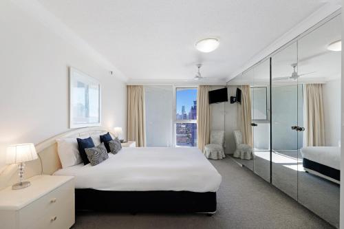 a bedroom with a large bed and a large window at ULTIQA Beach Haven on Broadbeach in Gold Coast