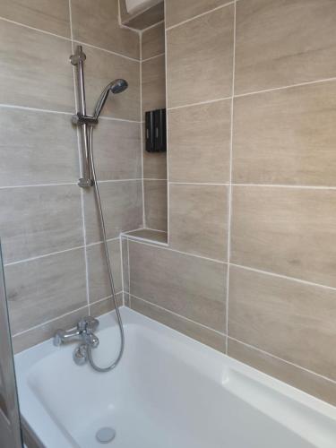 a shower in a bathroom with a bath tub at Les suites frontalières T3 avec parking secteur Thionville Luxembourg in Basse-Yutz