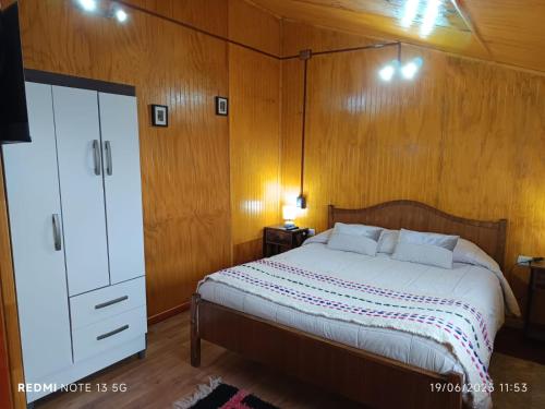 a bedroom with a bed and a dresser in it at CABAÑAS REY-MAR in Castro