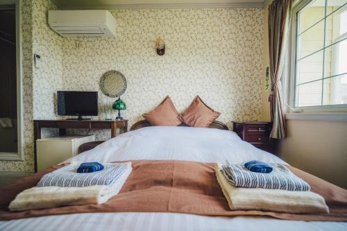 a bedroom with a bed with two towels on it at 伊豆集 Episode IZU in Ito