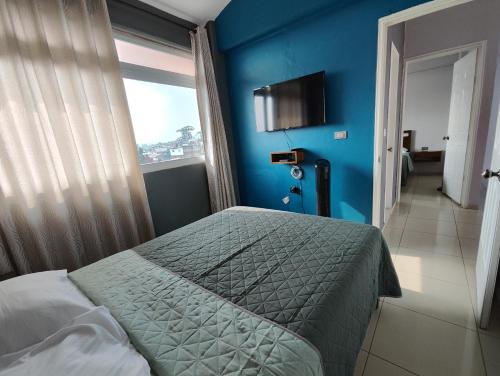 a bedroom with a bed and a blue wall at La colina in San Roque