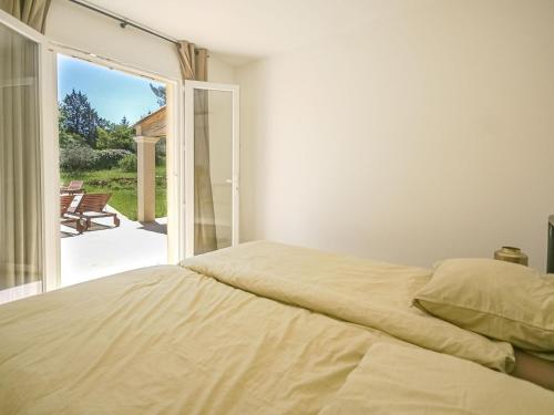 une chambre avec un lit et une porte coulissante en verre dans l'établissement La Noura, à Trans-en-Provence