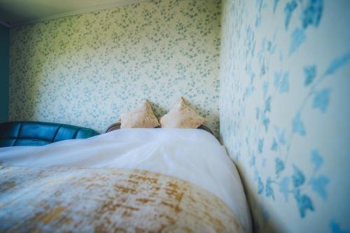 a bed with white sheets and pillows in a bedroom at 伊豆集 Episode IZU in Ito