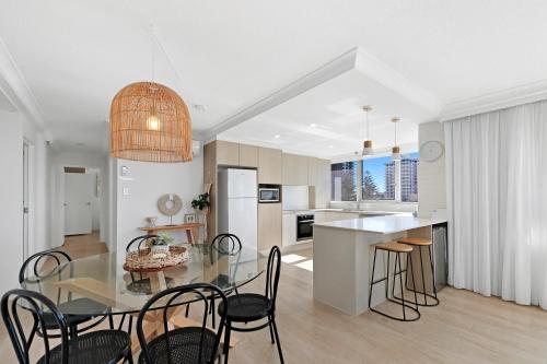 a kitchen and dining room with a glass table and chairs at ULTIQA Beach Haven on Broadbeach in Gold Coast