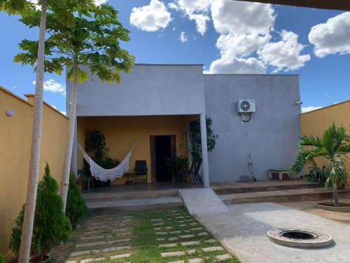 a house with a hammock in the courtyard at Refúgio Serra da Capivara 02 in Coronel José Dias