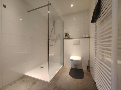 a bathroom with a toilet and a glass shower at De Kolibrie in Garderen