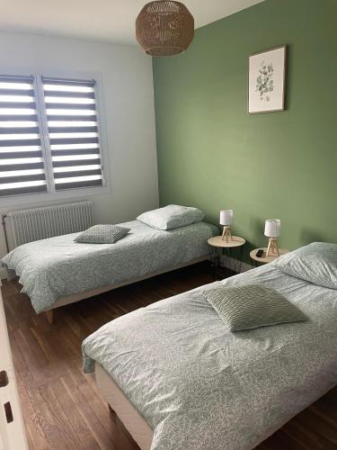 a bedroom with two beds and two lamps on tables at Maison Mara in Montliot-et-Courcelles