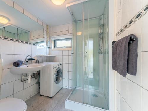 a bathroom with a sink and a washing machine at Vakantiehuis Vos in Hulshorst