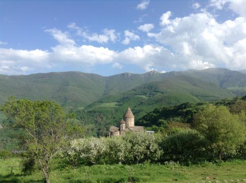 an old building in a field with mountains in the background at Aspet B&B in Tatʼev
