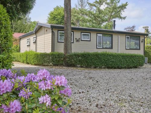a house with pink flowers in front of it at Vakantiehuis Vos in Hulshorst