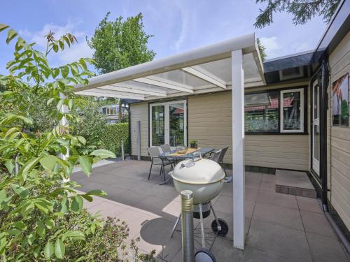a patio with a barbecue grill on a house at Vakantiehuis Vos in Hulshorst