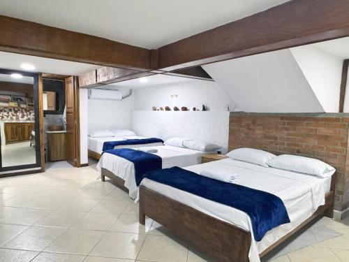 Ciudad BolívarにあるCasa Hotel Don Efraのレンガの壁、ベッド2台が備わるベッドルーム1室が備わります。
