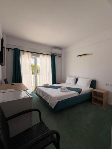 a bedroom with two beds and a chair in it at Sunrise Boutique in Costinesti