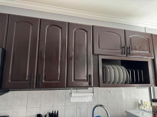 a kitchen with brown cabinets with plates in it at Classic king and queen suite in Schenectady