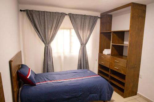 Un dormitorio con una cama y una cómoda y una ventana. en Hospedaje Castillo, en Casa Blanca La Corregidora