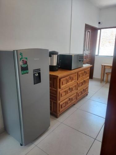 Una cocina con refrigerador de acero inoxidable y gabinetes de madera. en Hospedaje Castillo, en Casa Blanca La Corregidora