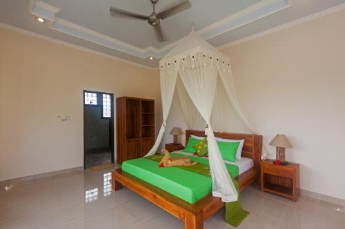 a bedroom with a green bed with a hammock at Cahaya Ubud Villa in Ubud