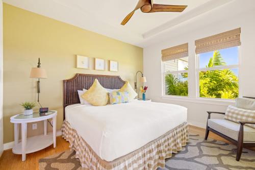 a bedroom with a large white bed and a window at Pili Mai 8K in Koloa