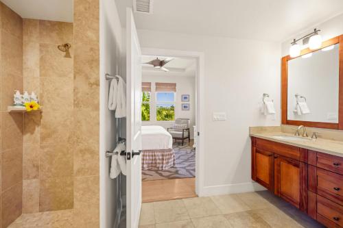 a bathroom with a shower and a sink and a mirror at Pili Mai 8K in Koloa