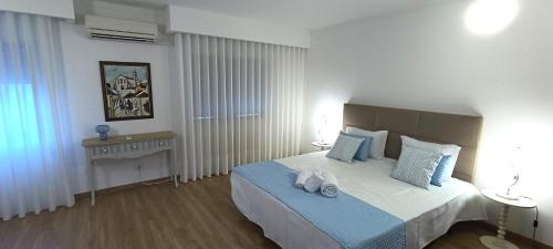 a bedroom with a large bed with blue pillows at Faro Station Eleven Guest House in Faro