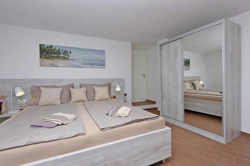 a bedroom with a large bed with a large mirror at Apartments with parking space Selce, Crikvenica - 24450 in Selce