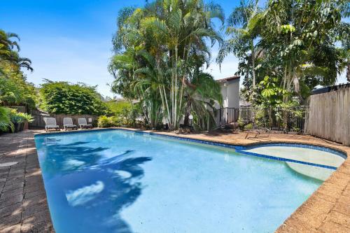 a swimming pool in a yard with palm trees at 16KAT Holiday Noosa Style, Great location, Pet Friendly in Noosa Heads
