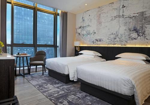 two beds in a hotel room with a large window at Zhuhai Langyue Hotel in Zhuhai
