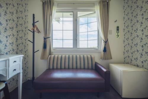 a living room with a couch and a window at 伊豆集 Episode IZU in Ito