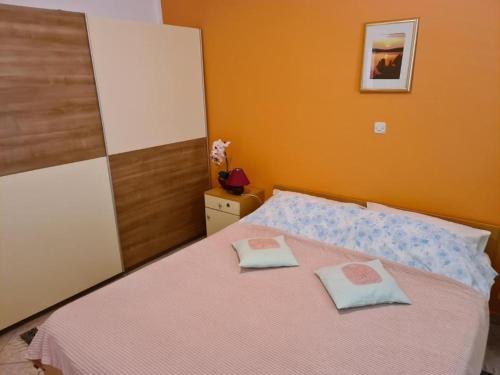 a bedroom with a bed with two pillows on it at Family-friendly apartments with swimming pools Opatija - Pobri, Opatija - 24607 in Matulji