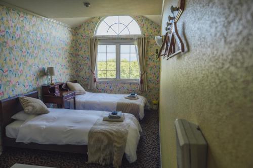 a hotel room with two beds and a window at 伊豆集 Episode IZU in Ito